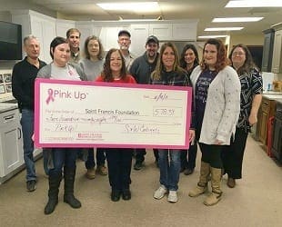 S&W employees hold a giant check for pink up fund raiser